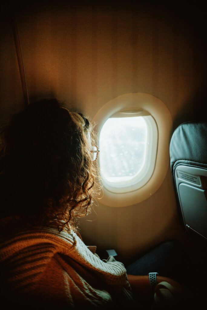 woman stares out airplane window