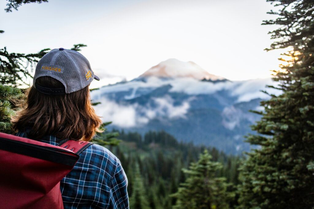 woman stares off at the distant mountain peak. 