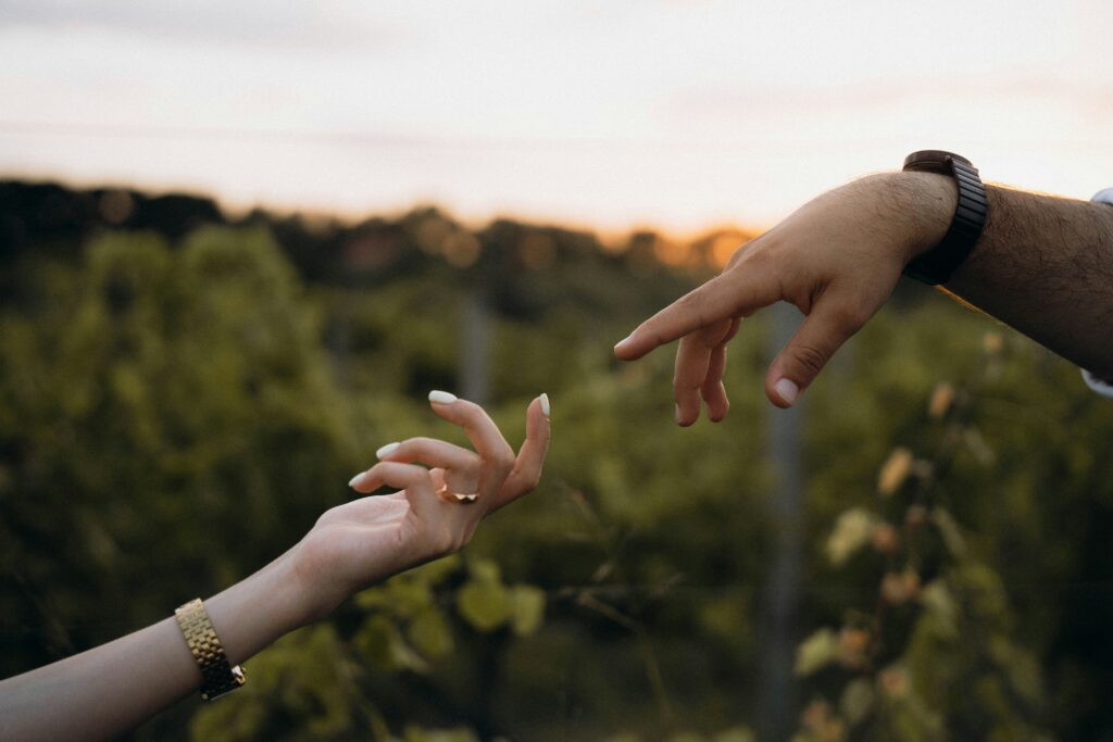 two hands reaching in connection, a man and a woman. 