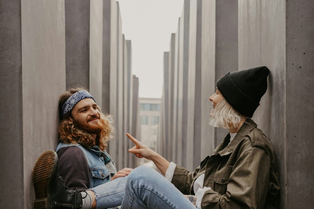 two strangers chatting like old friends, comfortably sat in a bright alley way.